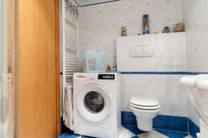 a bathroom with a washing machine and a toilet at Appartamento Moser P in Levico Terme +26 photos
