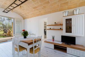 a dining room with a table and a tv at Dimora Balu' in Parabita