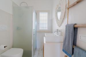 a white bathroom with a toilet and a sink at Dimora Balu' in Parabita