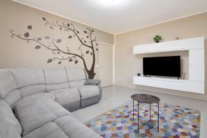 a living room with a couch and a tree mural at Colico Center in Colico
