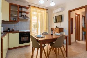 a kitchen and dining room with a wooden table and chairs at Appartamento Vacanza Gliaca in Piraino +18 photos