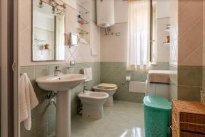 a bathroom with a sink and a toilet and a mirror at Appartamento Vacanza Gliaca in Piraino
