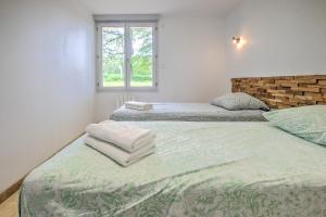 two twin beds in a room with a window at Gite Deodatus avec piscine in Cladech +23 photos