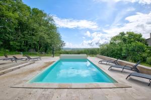 a swimming pool with benches around it with at Gite Deodatus avec piscine in Cladech