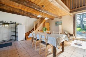 a kitchen and dining room with a table and chairs at Le Fenil gîte avec piscine partagée in Saint-Thual
