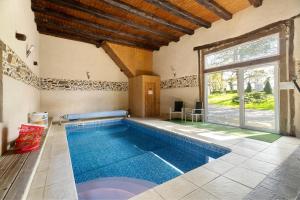an indoor swimming pool in a house at Le Fenil gîte avec piscine partagée in Saint-Thual