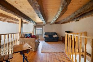 a living room with a couch and chairs in a house at Le Fenil gîte avec piscine partagée in Saint-Thual