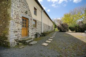 a brick building with a door on the side of it at Le Fenil gîte avec piscine partagée in Saint-Thual