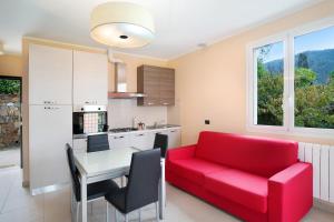 a living room with a red couch and a table at Appartamento Vallebona in Seborga +14 photos