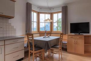 a kitchen with a table and chairs and a television at Florianshof in Tesimo +35 photos