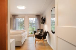 a bedroom with a bed and a desk and a mirror at Gästehaus Schwert in Salem