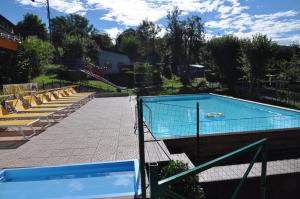 a swimming pool with lounge chairs around it at Camping Royal in Pettenasco