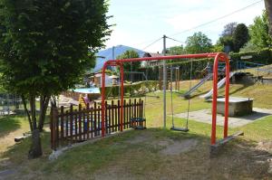 a park with a playground with a swing at Camping Royal in Pettenasco