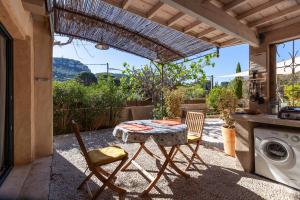a patio with a table and chairs and a washing machine at Maisonnette indépendante in Cassis