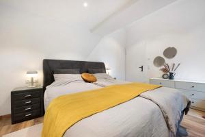 a bedroom with a bed with a yellow blanket on it at Eichengeflüster Waldhütte in Wagenfeld