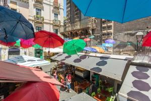 a group of colorful umbrellas hanging over a street at Spazio Pardo in Catania