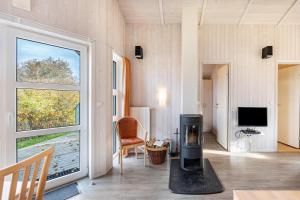 a living room with a fireplace and a large window at Skipper-Lodge Ost in Kosel
