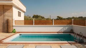 a swimming pool on a patio with a fence at Dimora Home Sweet Home with Private Pool in Putignano +23 photos