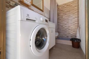 a white washing machine in a bathroom with a toilet at Dimora Home Sweet Home with Private Pool in Putignano