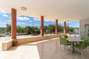 a patio with a table and chairs and large windows at Dimora Home Sweet Home with Private Pool in Putignano