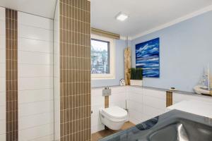 a bathroom with a toilet and a sink and a tub at Häuser am See in Königs Wusterhausen +26 photos