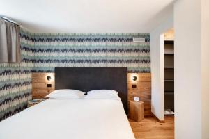 a bedroom with a white bed and a blue and white wall at Valgrisa Mountain Lodges 3 in Valgrisenche