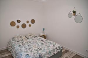 a bedroom with a bed and a white wall at Cocoon Spacieux Centre Joigny Z2 in Joigny