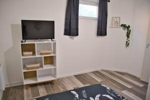 a living room with a tv on a white wall at Cocoon Spacieux Centre Joigny Z2 in Joigny