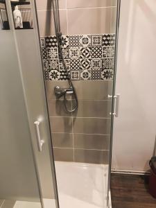 a shower with black and white tiles in a bathroom at Cocoon Spacieux Centre Joigny Z2 in Joigny +4 photos