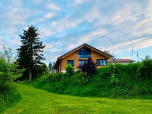 a house on top of a grassy hill at Ferienwohnung Morgensonne in Nagel