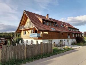 a house with a wooden fence in front of it at Ferienwohnung Heustüble in Hinterzarten