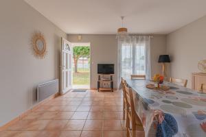 a dining room with a table and a television at Le Pin Franc in Valeyrac