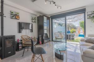 ein Wohnzimmer mit Stühlen, einer Couch und einem Fernseher in der Unterkunft Villa Igor in Cabasse