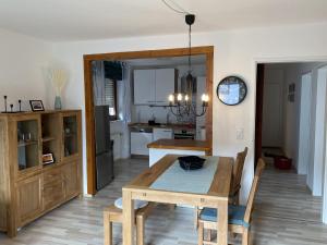 a kitchen and dining room with a wooden table and chairs at Fewo Am Edersee in Edertal