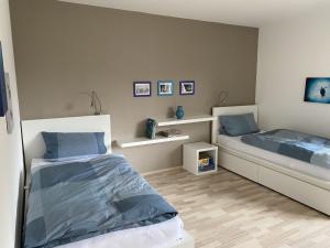 a bedroom with two beds with blue pillows at Fewo Am Edersee in Edertal