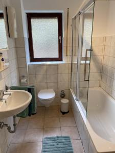 a bathroom with a sink and a tub and a toilet at Fewo Am Edersee in Edertal +13 photos