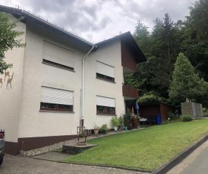 a white building with windows and a green yard at Fewo Am Edersee in Edertal