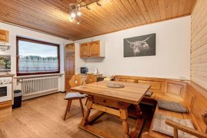 a kitchen with a wooden table and a wooden ceiling at Ferienwohnung Raab in Zandt