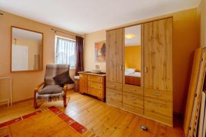 a bedroom with a dresser and a chair and a cabinet at Haus Gertrud in Monzelfeld