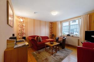a living room with a red couch and a table at Haus Gertrud in Monzelfeld