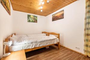 a bed in a room with a wooden ceiling at Ferienwohnung Raab in Zandt