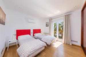 two beds in a room with a window at Villa Beatriz in Cala d´Or +34 photos
