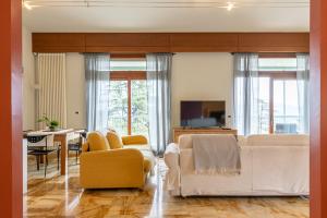 a living room with white furniture and a dining room at Al Castagneto Foresteria Lombarda in Montevecchia