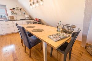 a kitchen with a wooden table and chairs at Behagliche Wohnung Hüfingen in Hüfingen