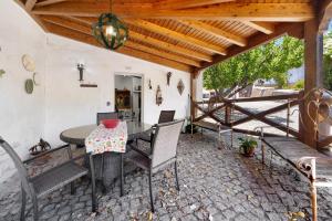 a patio with a table and chairs and a wooden ceiling at Quinta O Refúgio in Azambuja