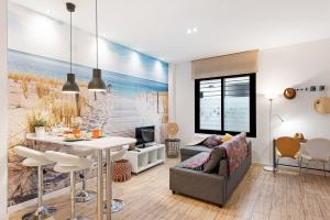 a living room with a beach scene on the wall at Suite Jinetes in Málaga