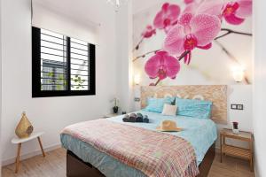 a bedroom with a bed with pink flowers on the wall at Suite Jinetes in Málaga +12 photos