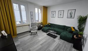 a living room with a green couch and a chair at Relax in der Röntgenstadt in Remscheid