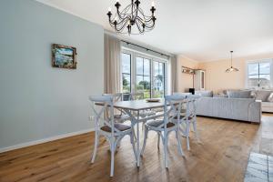 a dining room and living room with a table and chairs at Maison Mer Baltique in Dranske