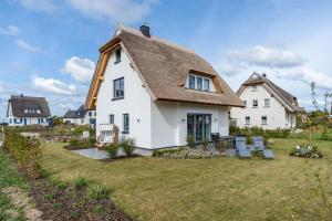 a large white house with a thatched roof at Maison Mer Baltique in Dranske